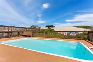 une grande piscine bleue sur une terrasse en bois dans l'établissement 6119 - Gone Coastal, à Nags Head 60 autres photos
