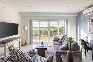 een woonkamer met een bank en een tv bij Landing Stunning 3BD Pool Gym in Naranja