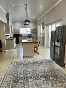 una grande cucina con tavolo e frigorifero di The Townhouse Mkhondo a Piet Retief