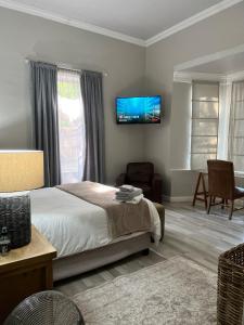 una camera da letto con un letto e una TV a parete di The Townhouse Mkhondo a Piet Retief