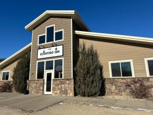 a building with a sign that reads the neighborhood inn at The Rushford Inn in Rushford