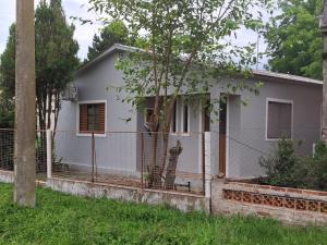 a small white house with a fence around it at Casa Hermosa in São Gabriel