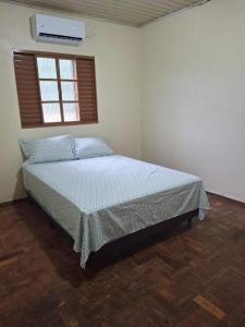 a bedroom with a bed in a room with a window at Casa Hermosa in São Gabriel