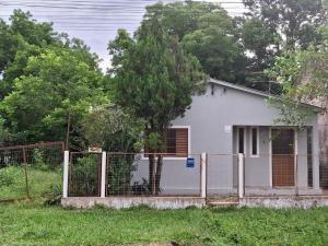 a white house with a fence in front of it at Casa Hermosa in São Gabriel +2 photos