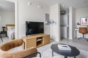 een woonkamer met een televisie en een tafel bij Blueground Central Berkeley rooftop nr UC Berkeley SFO-2124 in Berkeley