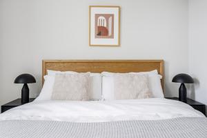 een slaapkamer met een wit bed met twee lampen bij Blueground Central Berkeley rooftop nr UC Berkeley SFO-2124 in Berkeley