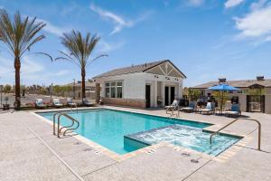 a swimming pool with palm trees and a house at Landing Incredible 2BD Gym in Phoenix