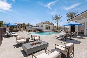 a patio with chairs and a pool with a fire place at Landing Incredible 2BD Gym in Phoenix