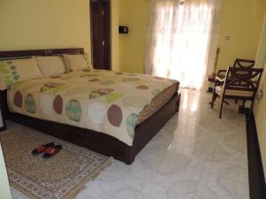 1 dormitorio con 1 cama y un par de zapatos en Asimba Guest House en Mekʼelē