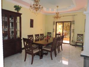 uma sala de jantar com uma mesa e cadeiras e um lustre em Asimba Guest House em Mekʼelē