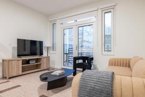 un soggiorno con un divano e una TV di Blueground Ward Two rooftop nr Prospect Hill BOS-1265 a Somerville