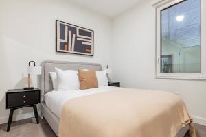 una camera da letto bianca con un letto e una finestra di Blueground Ward Two rooftop nr Prospect Hill BOS-1265 a Somerville Altre 18 foto