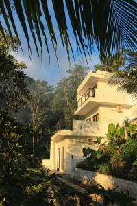 a white building with trees in front of it at SIRUS Resort Tagulandang in Kisihang