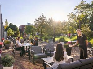 a woman standing in front of a group of people at Novotel Wrocław City in Wrocław