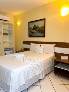 a bedroom with two beds and a picture on the wall at Hotel Monólitos in Quixadá