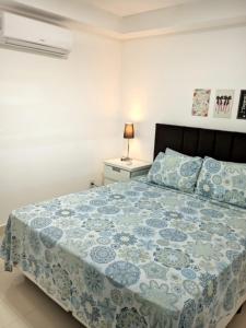 una camera con un letto con copriletto blu e bianco di Buenos Aires 605 a Osório