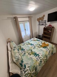 une chambre avec un lit avec une couette colorée dans l'établissement Charmant T1 au calme, à Cernay 4 autres photos