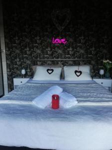 a bed with two towels and a sign that reads love at Cabalove in Quissac
