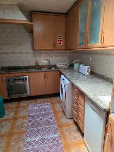una cucina con lavandino e lavastoviglie di Casa do Lidador à Beira-Rio a Vila do Conde