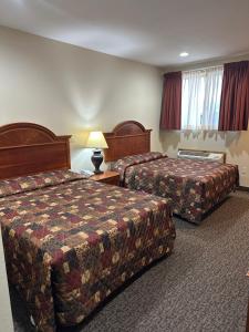 a hotel room with two beds and a lamp at The Rushford Inn in Rushford +12 photos