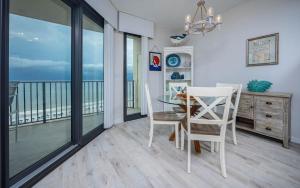 a dining room with a table and chairs and a balcony at Phoenix East 1108 in Orange Beach