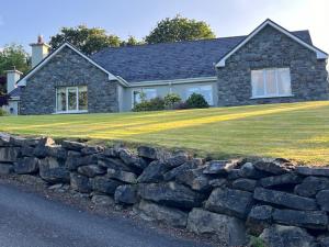 a stone retaining wall in front of a house at Ríocht Fódla 2 in Killarney