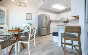a kitchen with a table and a stainless steel refrigerator at Phoenix East 1108 in Orange Beach