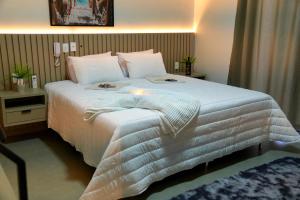 een slaapkamer met een groot wit bed met verlichting bij Hotel & Pousada Porto Ubá in Lidianópolis +38 foto's