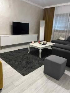 un soggiorno con una TV, un divano e un tavolo di Relax Loft a Oradea