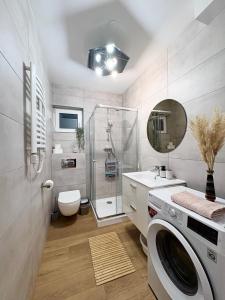 une salle de bains avec lave-linge et lavabo dans l'établissement Widokówka Zacisze, à Brodnica Dolna