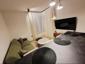 een woonkamer met een bank en een tv bij Infinity Apartment & Privat Garage in Sarajevo +12 foto's
