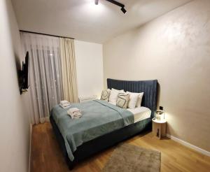 een slaapkamer met een bed met handdoeken erop bij Infinity Apartment & Privat Garage in Sarajevo