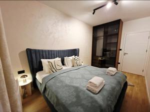 een slaapkamer met een bed met twee handdoeken erop bij Infinity Apartment & Privat Garage in Sarajevo