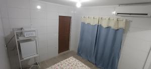 un bagno con doccia e tenda da doccia blu di Taberna dos Castilho 1 a Bertioga