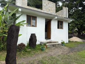 a white house with a tree in front of it at Fireworks bungalows in White Sands