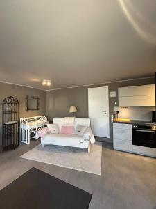 a living room with a white couch and a kitchen at Helle Souterrain-Wohnung mit eigenem Eingang in Erftstadt