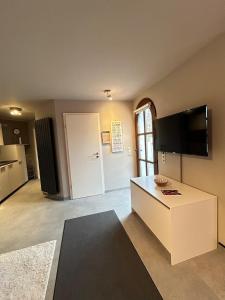 a living room with a white table and a tv at Helle Souterrain-Wohnung mit eigenem Eingang in Erftstadt