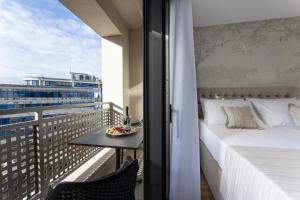 a bedroom with a bed and a table on a balcony at Sunday Residence Split in Split