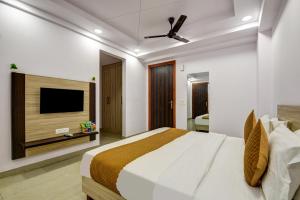 une chambre avec un lit et une télévision à écran plat dans l'établissement Hotel Town Stay Near Rajiv Gandhi Cancer Hospital Rohini, à New Delhi