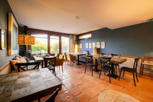 un ristorante con tavoli e sedie in una stanza di Hotel Boutique Barosse Family & Pet Friendly Roo a Jaca