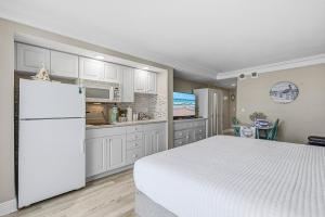 een keuken met witte kasten en een witte koelkast bij Daytona Beach Resort 1004 in Ortona