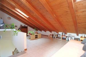 a large living room with wooden ceilings and a large floor at Urban Oasis in Cormano