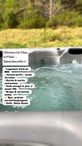 Gros plan sur la vitre d'une baignoire remplie d'eau dans l'établissement Cour ancienne école avec Jacuzzi privé, à Gérardmer 3 autres photos