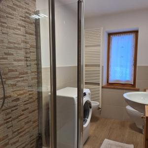 een badkamer met een wasmachine en een wastafel bij Cesa de Conesel in Colle Santa Lucia +61 foto's