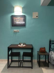 a table and two chairs in a room with a blue wall at Palms Cosy affordable homely flat in Arpora