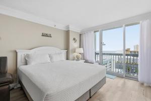 een slaapkamer met een wit bed en een groot raam bij Daytona Beach Resort 1004 in Ortona +17 foto's