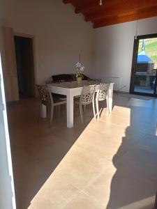 a dining room with a white table and chairs at villa VM in Maniace +8 photos