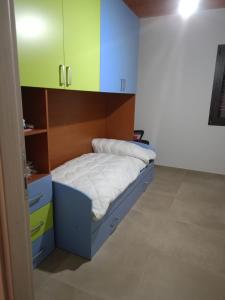 un piccolo letto in una stanza con armadi verdi e blu di villa VM a Maniace