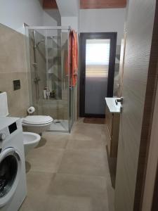a bathroom with a washing machine and a toilet at villa VM in Maniace