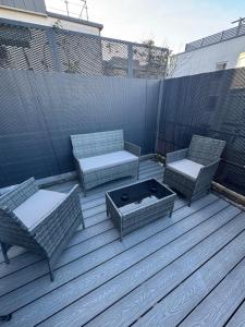 three chairs and a fire pit on a deck at Timeless Spacious 1bedroom Duplex apartment with balcony in Shoreditch in London